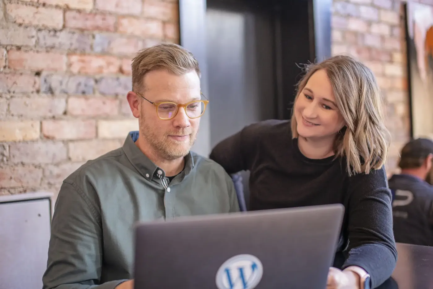 Ryan and Cassie from Hello Hudson working together at a laptop
